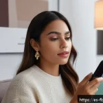 증강 현실 AR  뷰티 - A young Hispanic woman using a virtual makeup app on her smartphone, sitting comfortably at home wit...
